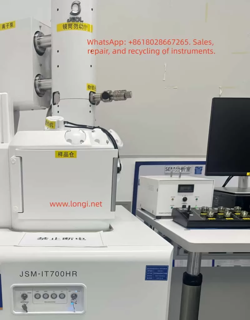 JEOL JSM-IT700HR/LA analytical scanning electron microscope front view with sample chamber, electron column, ion pump, camera, control monitor, and labeled SEM components in a laboratory.