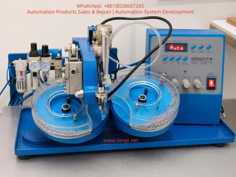 Realistic blue rhinestone hotfix setting machine with dual transparent feeding plates, pneumatic nozzle head, vacuum tubes, air regulator, control panel, and rhinestones on a workbench.