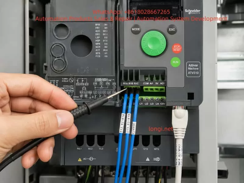 Close-up of Schneider ATV310 Modbus wiring and R1 relay feedback terminals being checked with a test probe.