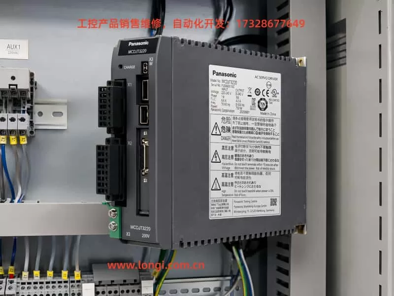 Panasonic MCDJT3220 MINAS LIQI AC servo drive mounted inside an electrical control cabinet, showing the model label, connectors, and industrial wiring layout.