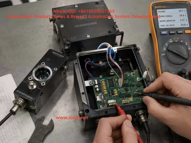 Technician testing an opened MARPOSS TBD laser tool breakage detector on a repair bench, measuring the PCB, signal wiring, laser enable input, signal monitor, and Tool OK output with a multimeter.