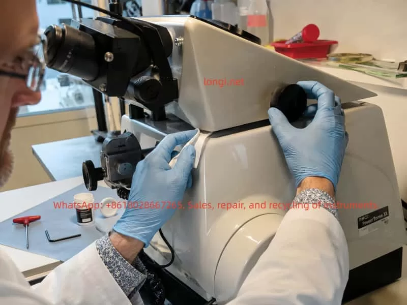 Laboratory technician inspecting and servicing the stereomicroscope holder mechanism on an RMC PowerTome XL ultramicrotome, checking the side adjustment disc and pivot area for friction, binding, or lubrication issues.